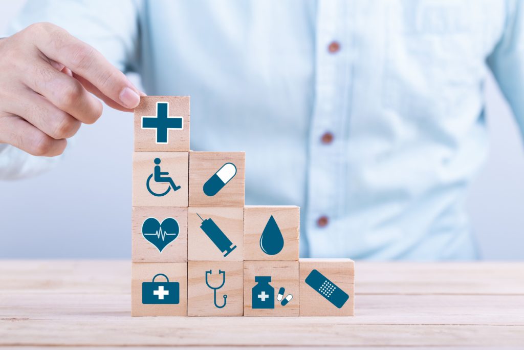 cette photo montre quelqu'un en train de faire une pile de cubes sur lesquels sont dessinés des symboles médicaux.